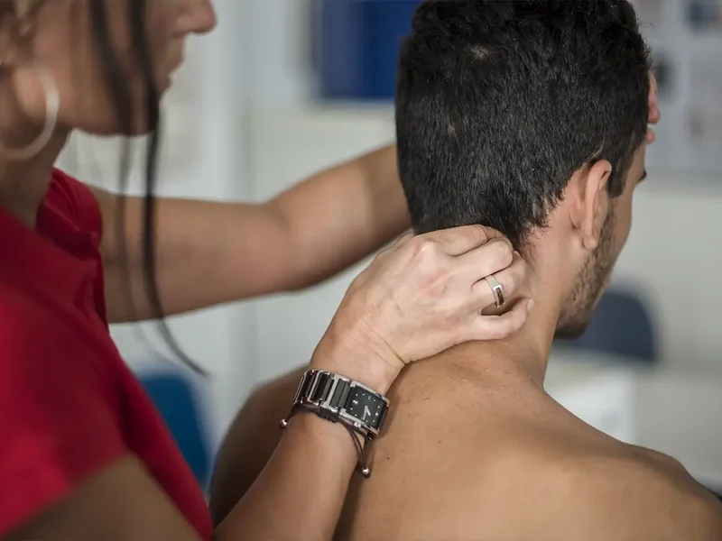 Physical therapist assessing a patient's neck movement and mobility
