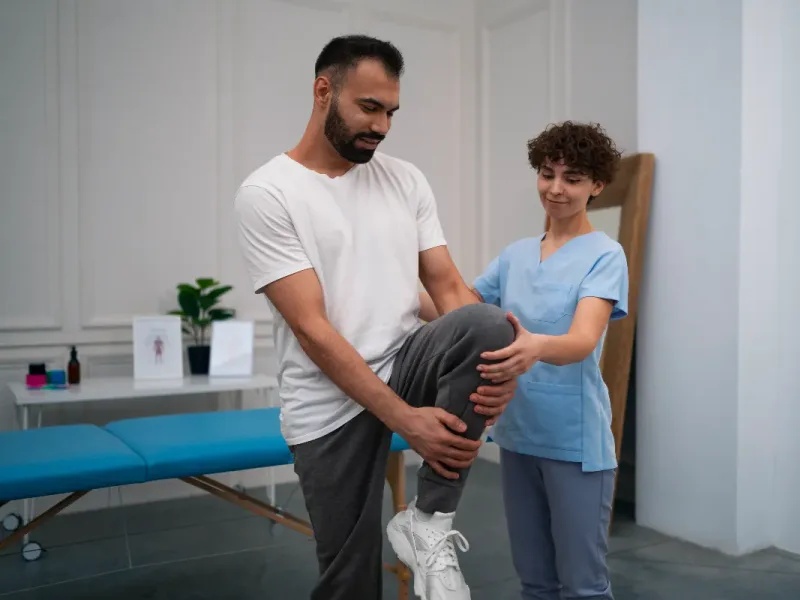licensed physical therapist guiding a patient through a knee mobility exercise during a physical therapy visit in Honolulu