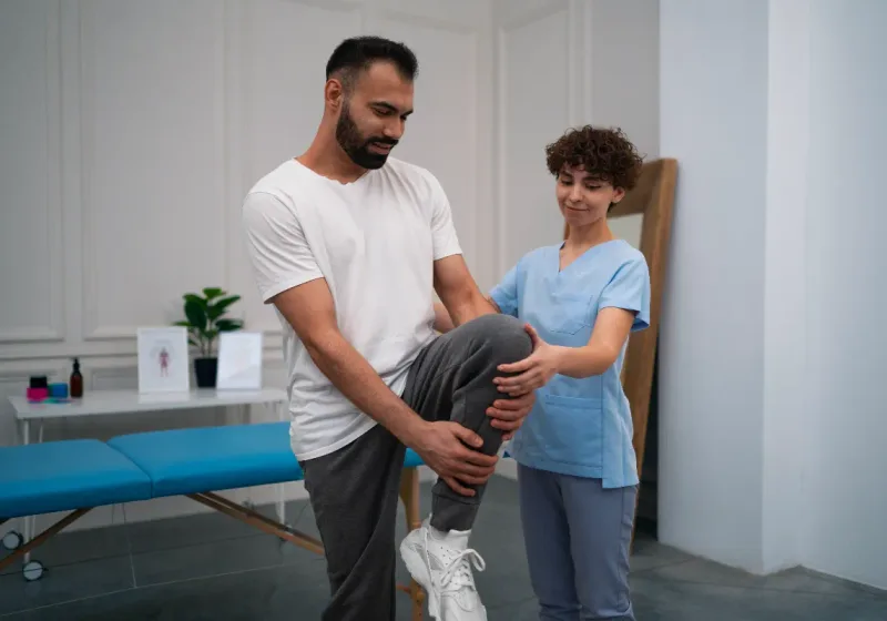 Physical therapist guiding a patient through a knee mobility exercise at Action Rehab Physical Therapy in Honolulu